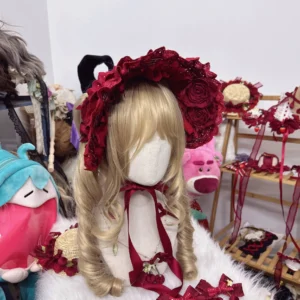 deep red rose lolita bonnet with decorative chin straps and 3d fabric roses angled front perspective
