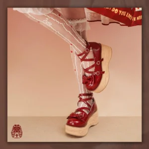Red glossy lolita platform Mary Jane shoes worn with lace stockings and ruffled skirt hem visible in low-angle side view showing cross buckle straps