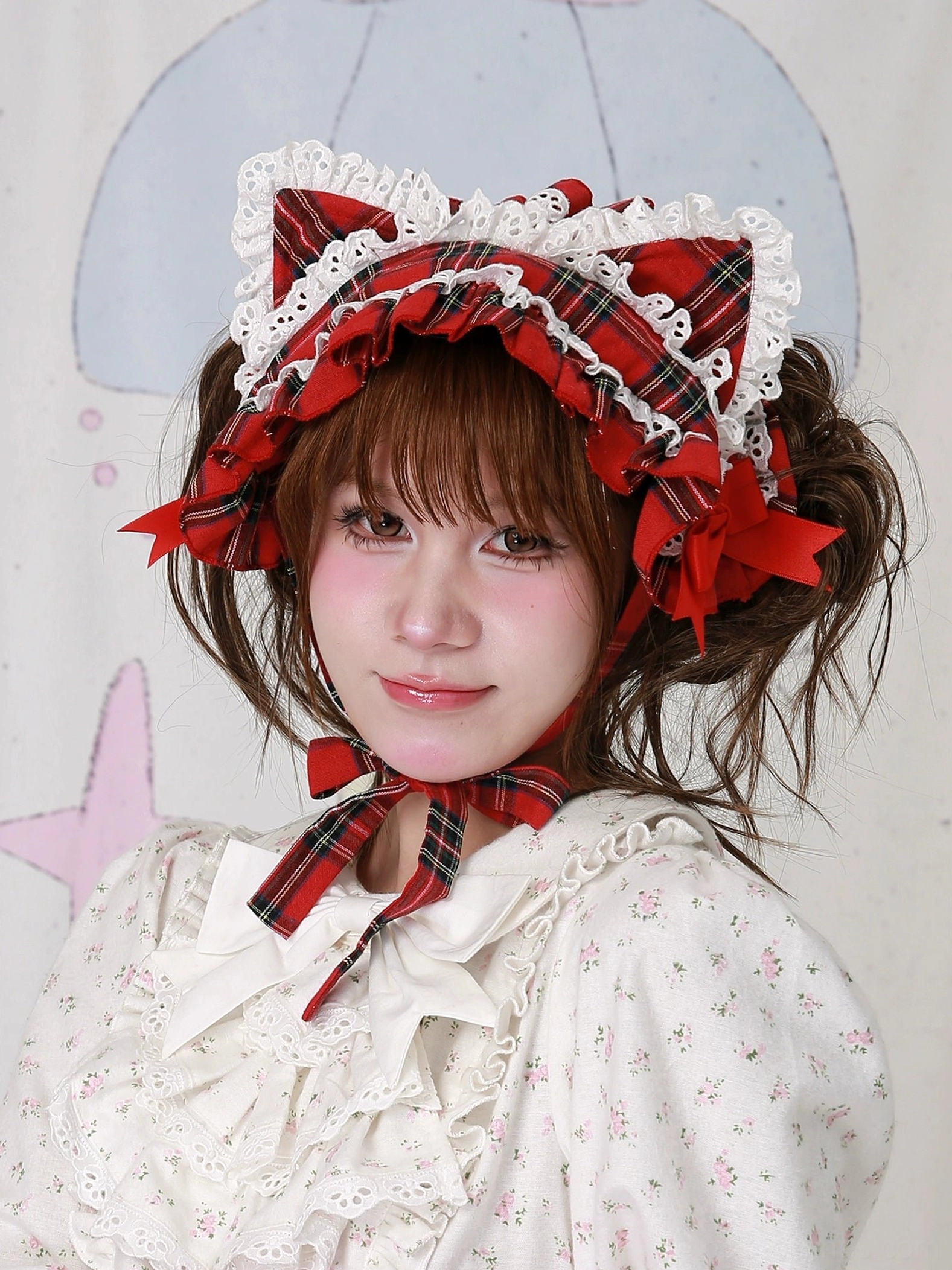 Neatly fitted red plaid cat ear sweet lolita hairband with coordinated matching neck tie ribbon detail, frontal casual portrait view, model in white floral lolita coordinate, showing complete headdress ensemble