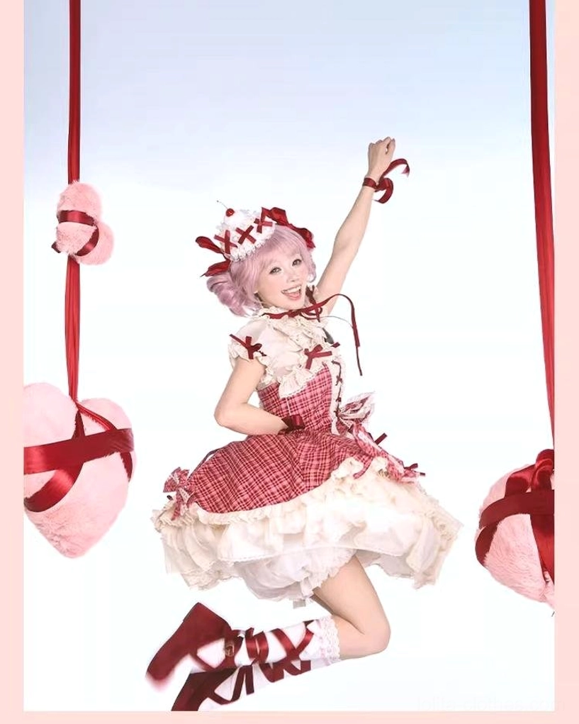 Red plaid lolita cake JSK dress flat lay product photography showing full dress construction, plaid pattern, tiered skirt, bow decorations