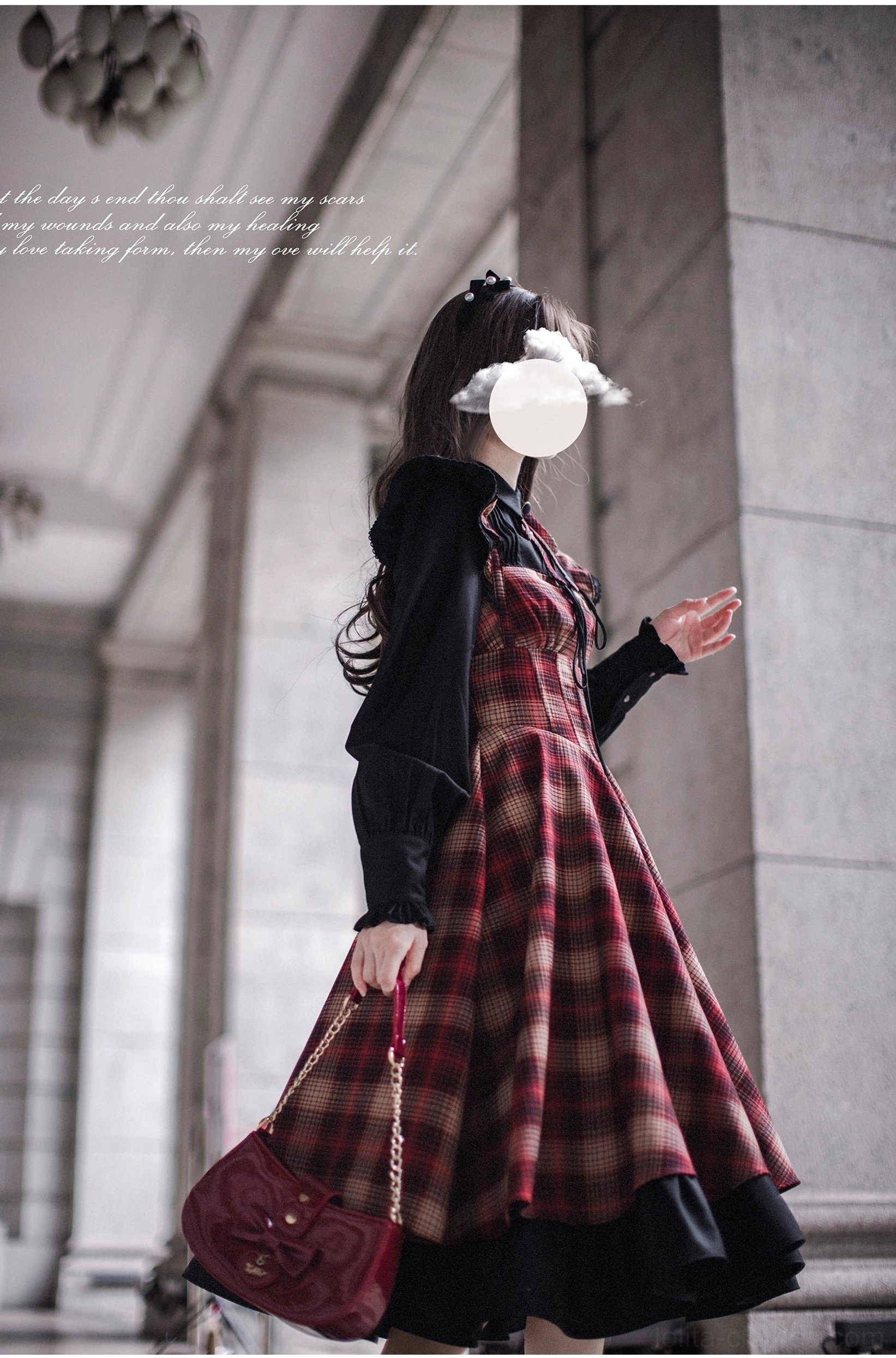 Red plaid lolita JSK with black long-sleeve blouse featuring ruffled cuffs - back three-quarter view showing design details and A-line silhouette in classical stone building corridor