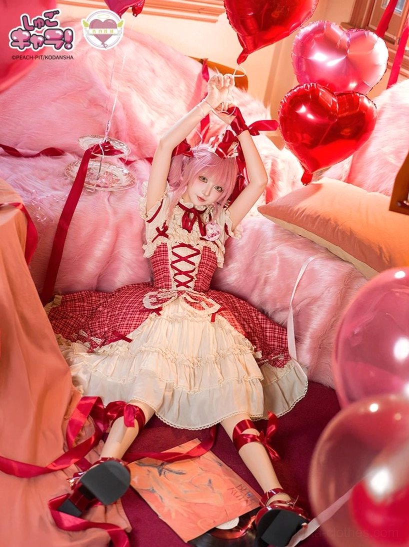 Full-body lying down view of model wearing red plaid lolita JSK dress on pink bed with heart-shaped balloons, hands raised holding balloon ribbons, vintage bedroom setting
