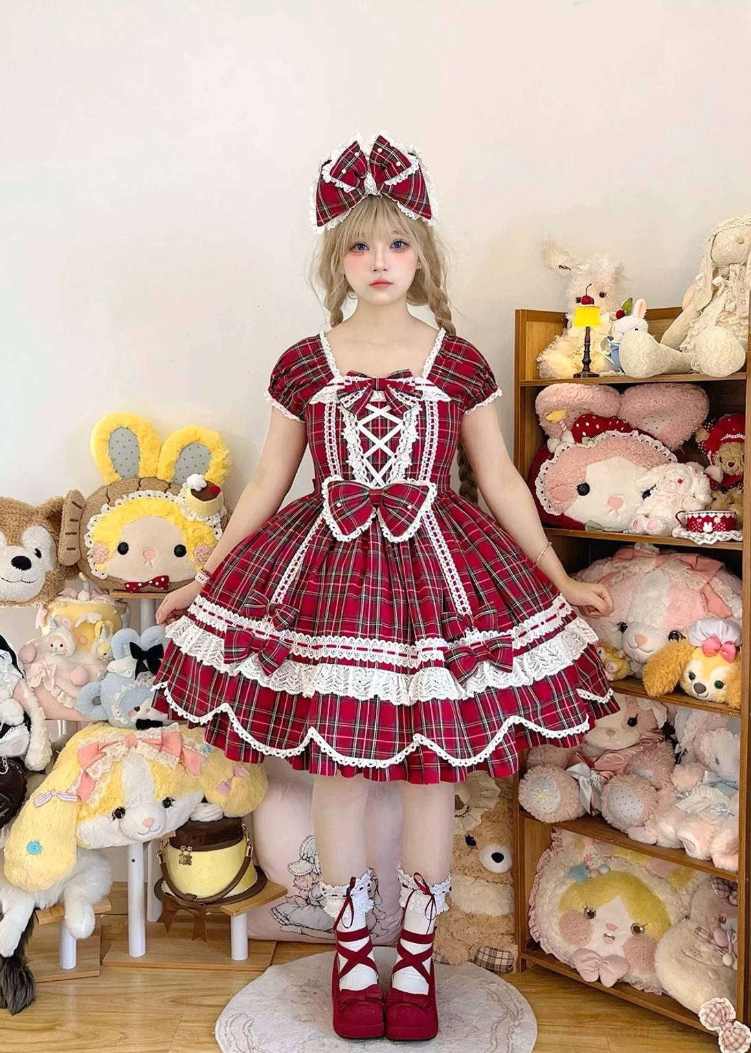 Red tartan plaid Old School lolita one-piece dress with petal-shaped hem, pearl-adorned front bow, and square neckline shown on model in indoor studio setting