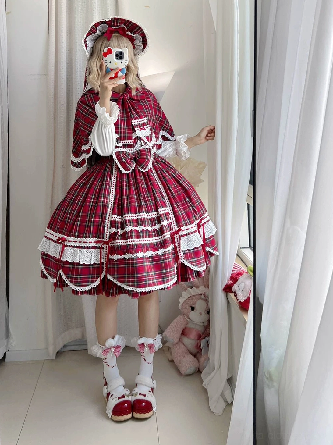 Red tartan lolita jumper skirt matching bonnet short capelet front three-quarter full body cosplayer selfie simple indoor space red mary jane shoes scalloped lace trims matching plaid accessories full plaid skirt