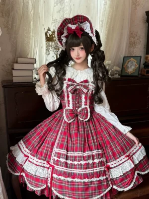 Red tartan old school lolita JSK dress with matching rabbit ear bonnet worn by lolita model in vintage bedroom setting paired with white ruffled blouse, scalloped white lace skirt trim, large front waist bow, A-line plaid silhouette front three-quarter view