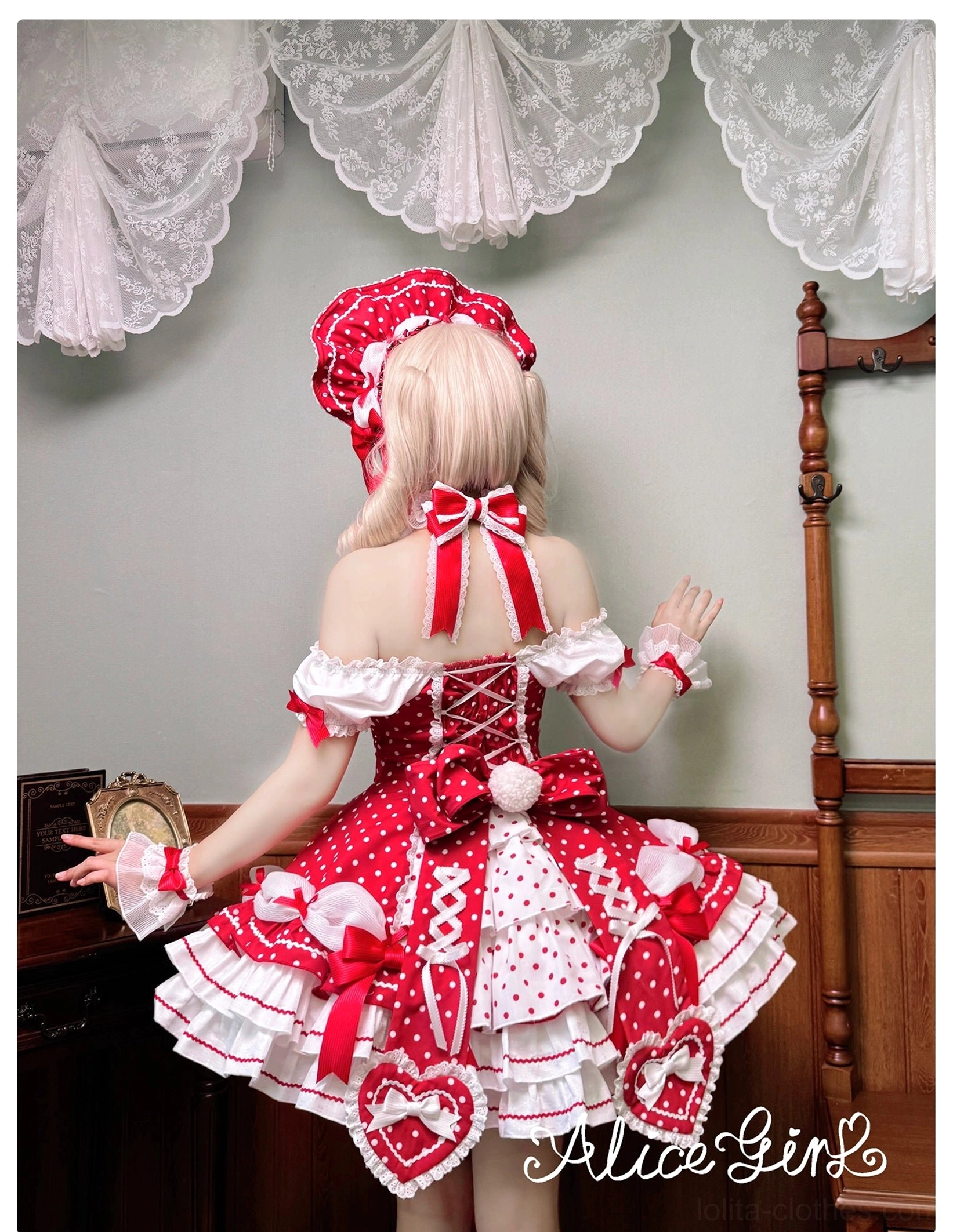 Red polka dot Lolita one-piece dress back view model wearing with matching bonnet and large back bow decoration heart skirt accents