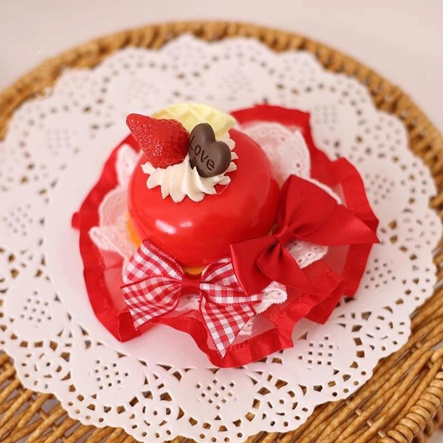 Red strawberry dessert Lolita hairpin flat lay showing glossy red cake strawberry charm chocolate detail gingham and red bows with lace frills on white background