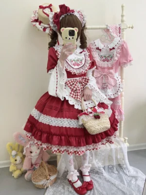 Red Strawberry Sweet Lolita OP dress with detachable gingham apron and white lace trimmings, worn by model with twin tails and hair headband, front full-body mirror view