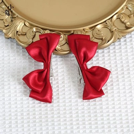Red Sweet Lolita satin bow hair clips pair flat lay display showing vibrant red satin bows with metal alligator clip attachment and premium fabric detail