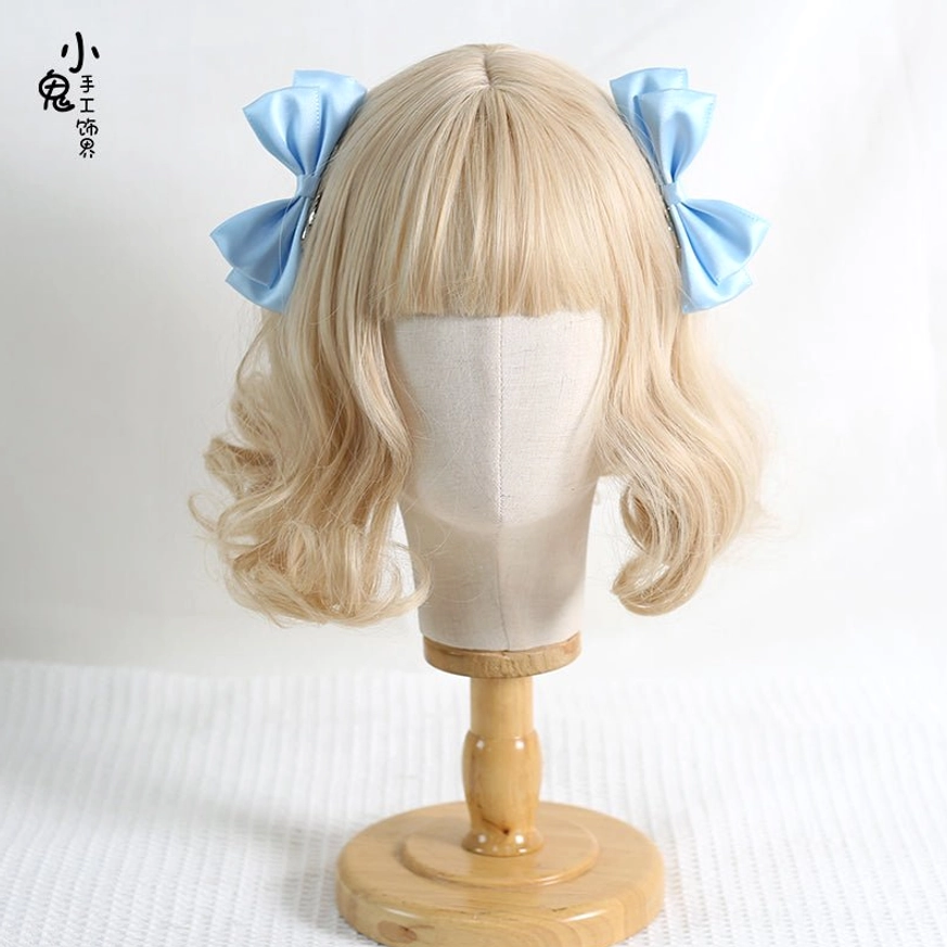 Red Sweet Lolita bow hair clips pair headshot on blonde curly wig mannequin with wooden stand showing rich crimson satin finish and dual-side bow set