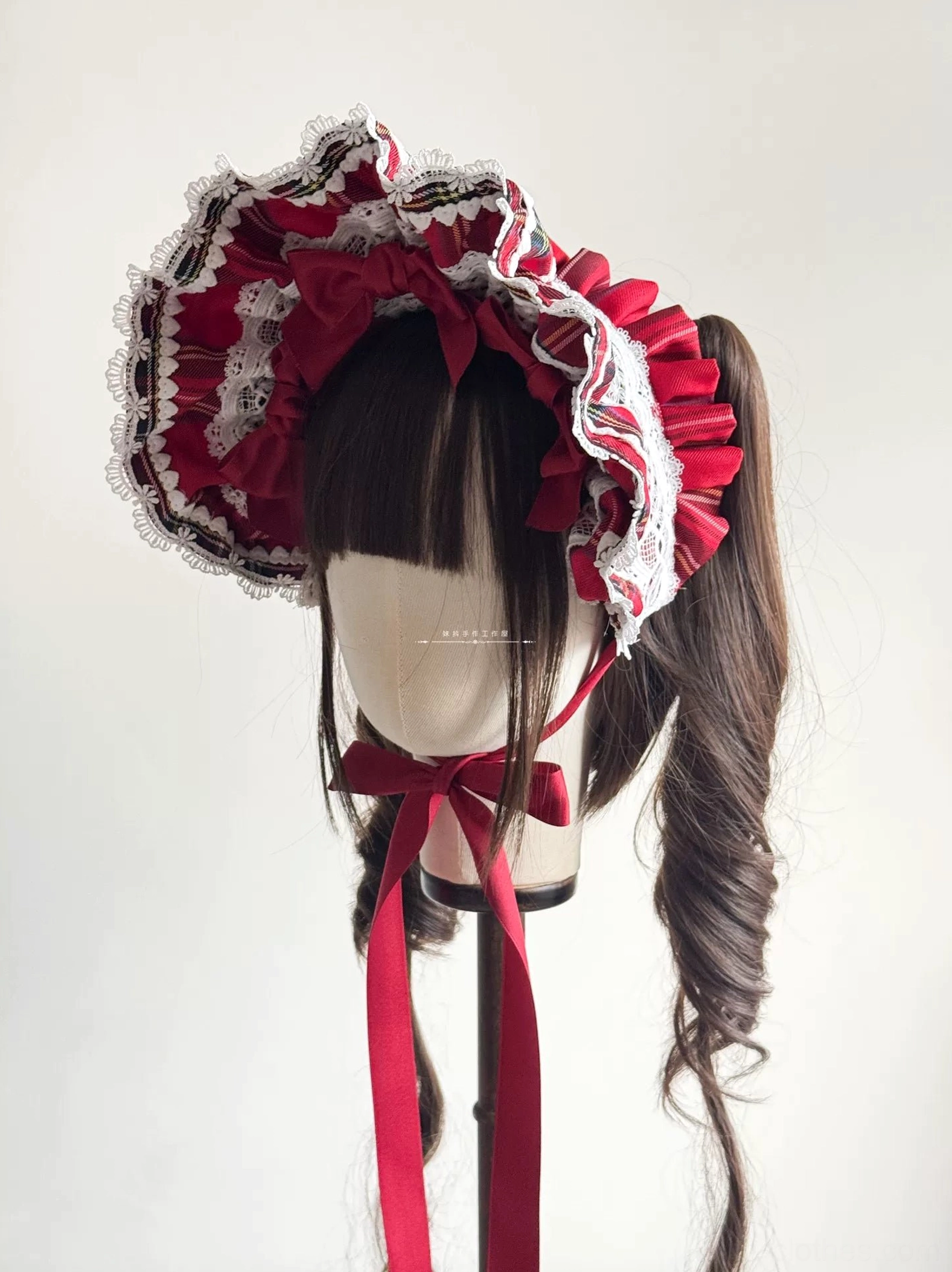 Compact ruffled red tartan Lolita BNT headdress designed for ponytail hairstyles shown on mannequin with twin curly ponytails, displaying ruffled lace trim and tartan fabric accent details