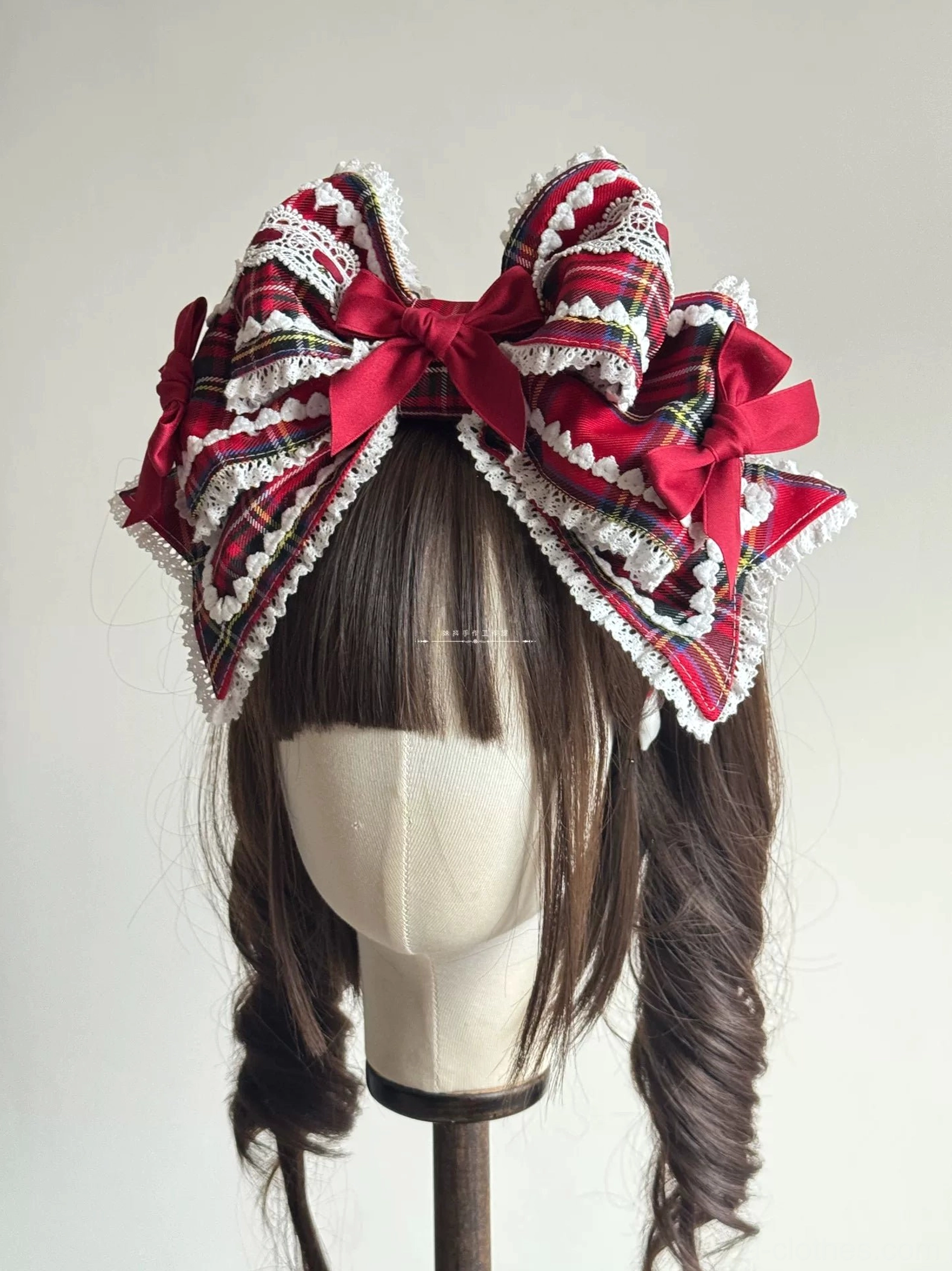 Symmetrical double-sided red tartan Lolita hair bow featuring wire-edged layered construction, paired wine-red satin bows, white lace trim, and dimensional design on mannequin