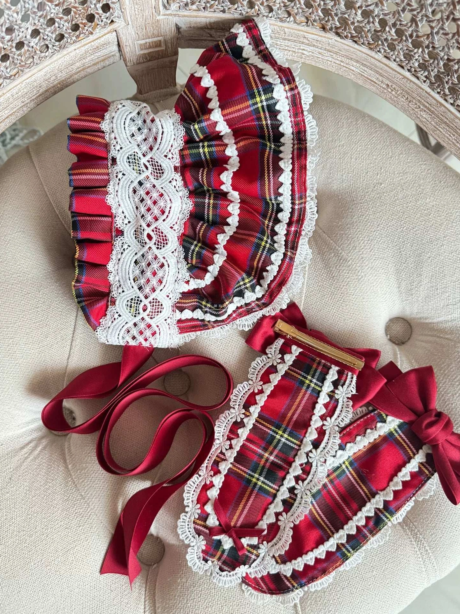 Close-up detail of red tartan Lolita headdress showing white ruffled lace trim quality, wine-red satin ribbon bow, and plaid fabric pattern construction
