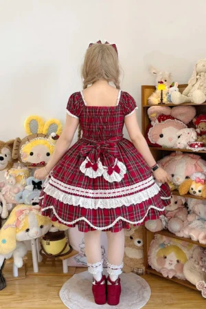 Back view of red tartan plaid lolita OP dress showcasing large back bow with heart-shaped lace trims, scalloped petal hem, and square back neckline