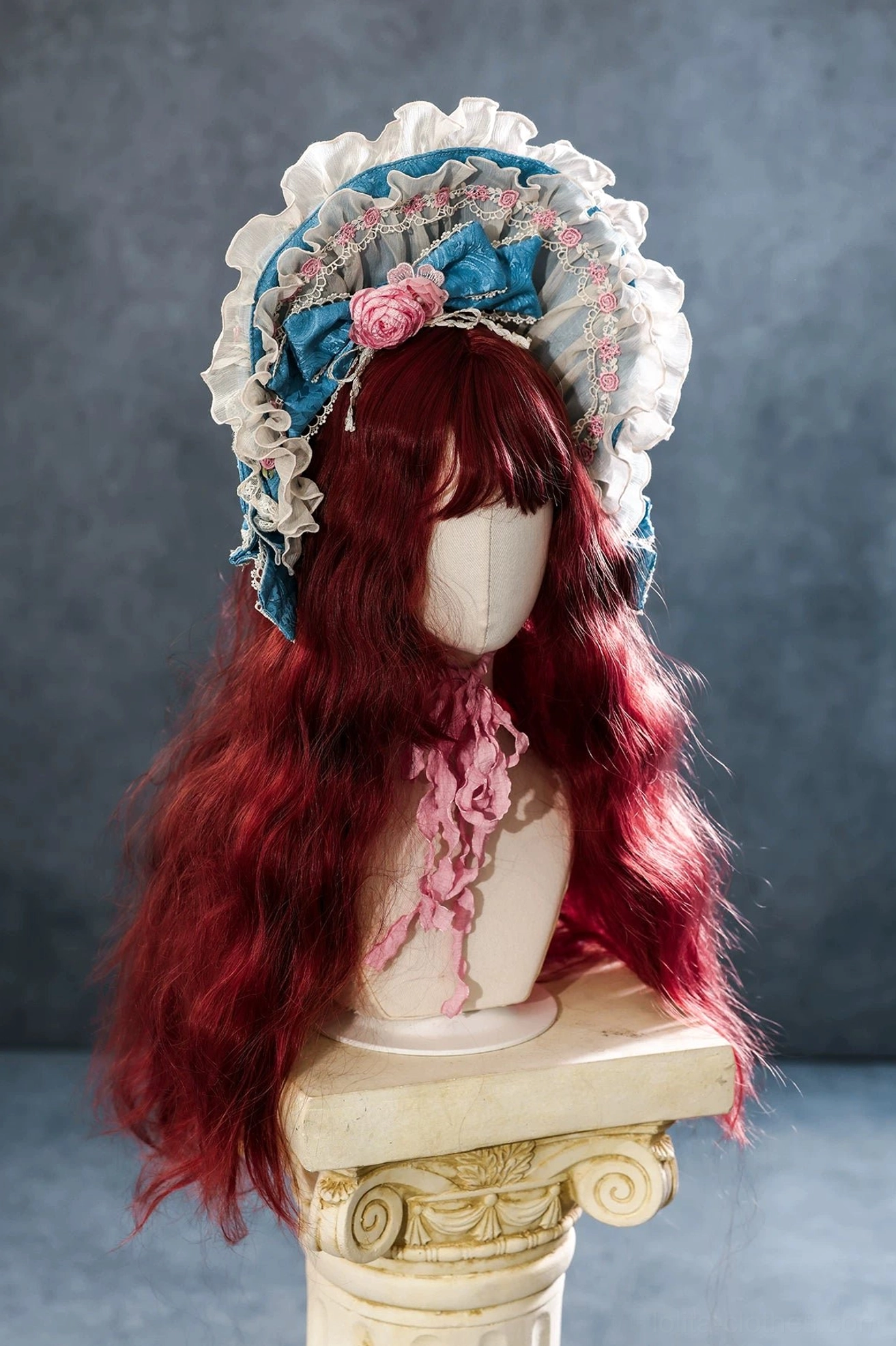 Vintage Rococo lolita bonnet and pink ribbon necktie set displayed on wooden mannequin with deep red curly wig, featuring teal blue and white lace trim and pink fabric rose