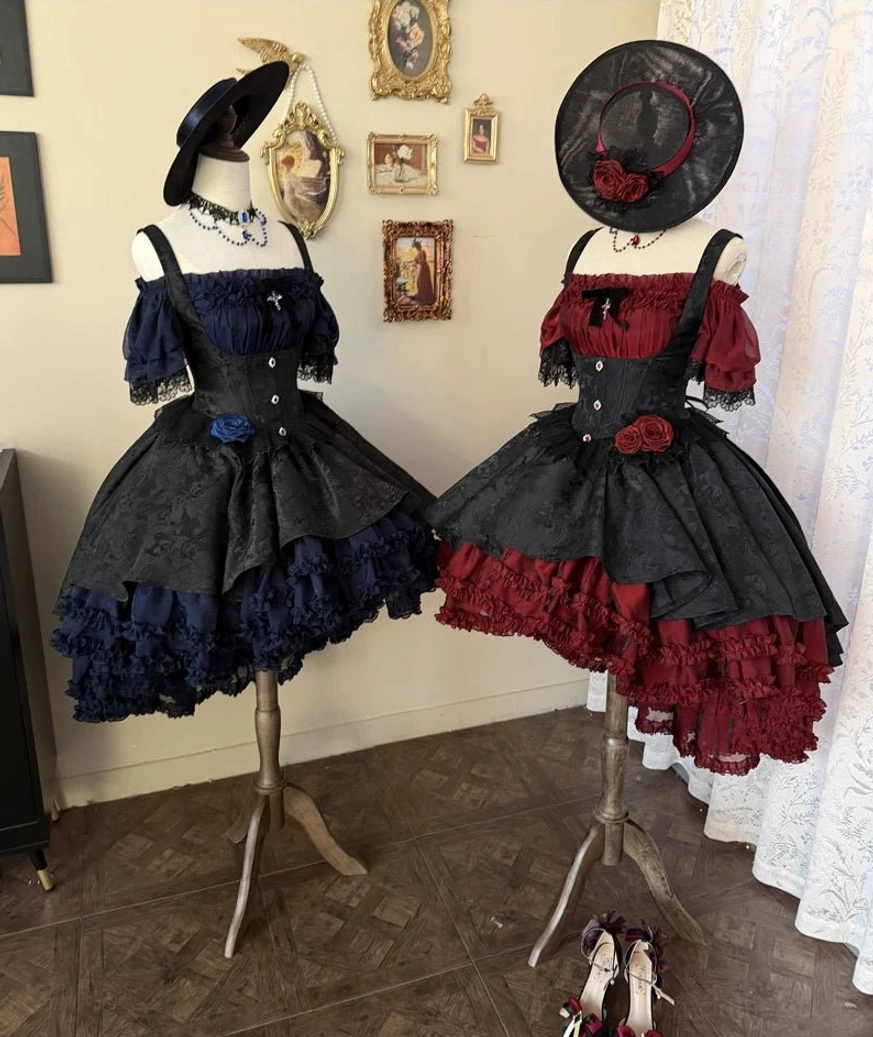 Two variants of Gothic Lolita boned JSK dresses on mannequins showing off-shoulder sleeves, high-low ruffled hems, matching hats and chokers with decorative accessories