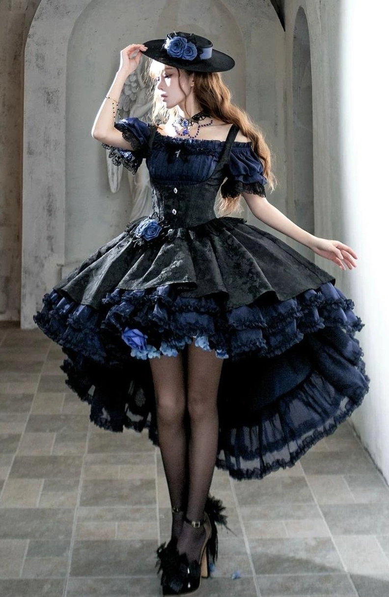 Navy-blue black Gothic Lolita boned JSK dress front view showing corset bodice, high-low layered ruffled hemline with blue flower decorations and formal hat styling
