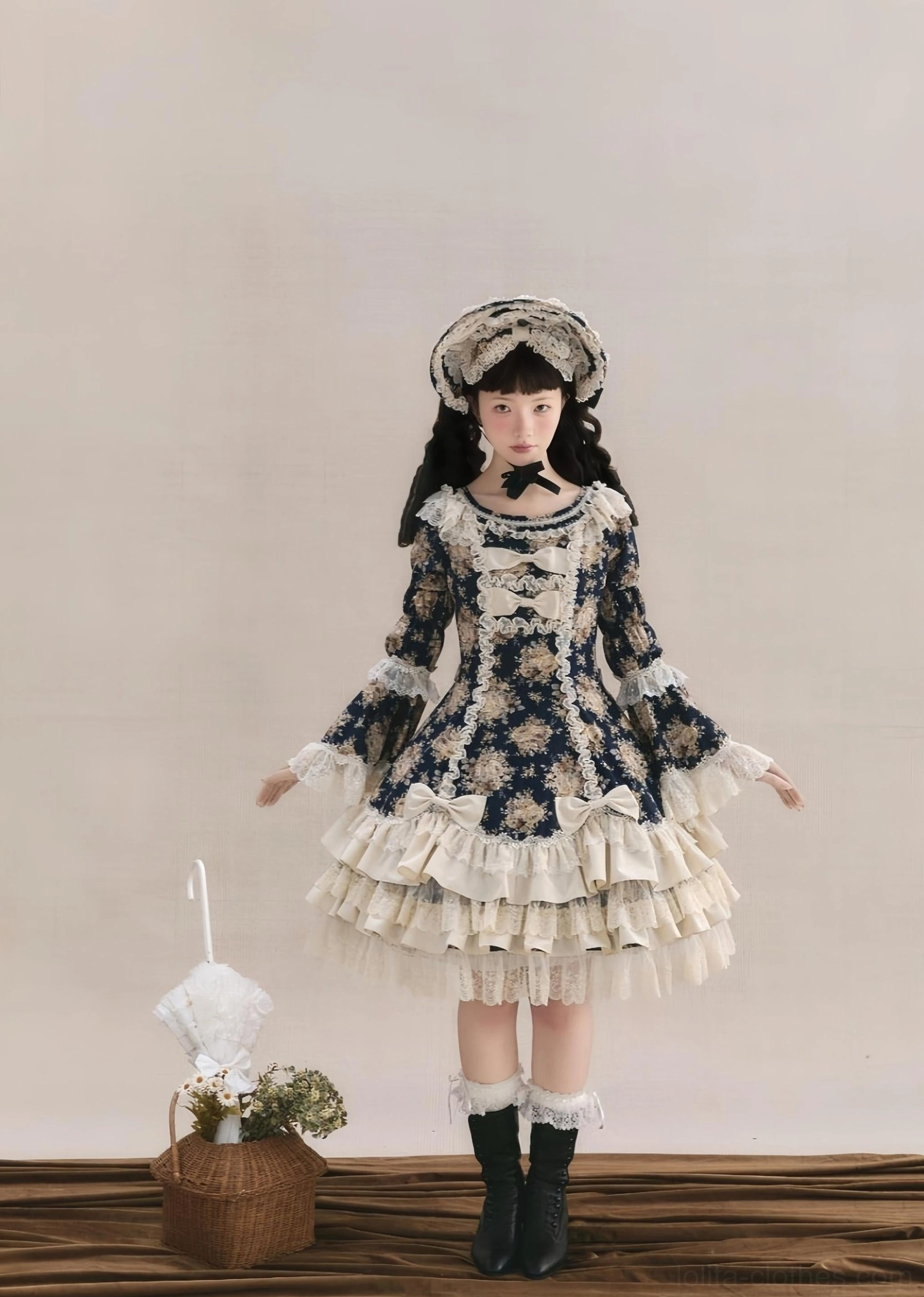 Old School Lolita OP dress with navy floral rose print and cream ruffled tiered skirt, full-body front view with matching bonnet and vintage props