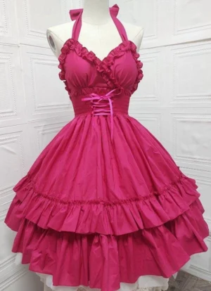 Rose red halter neck ruffle Lolita JSK dress featuring halter tie straps, ruffled sweetheart neckline, waist lace-up detail, and two-tiered ruffled full skirt shown on dress mannequin against embossed white wall