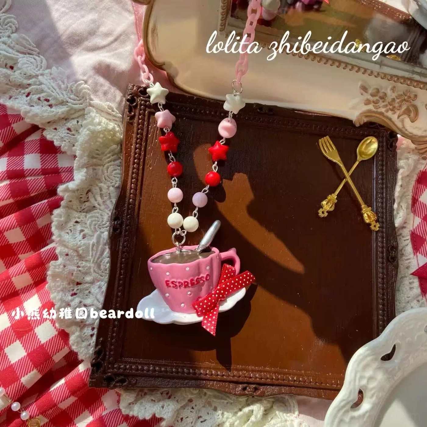 Rose red Old School Lolita beaded necklace with espresso cup pendant decorated with red polka dot bow and mixed red-pink-white bead chain on wooden tray