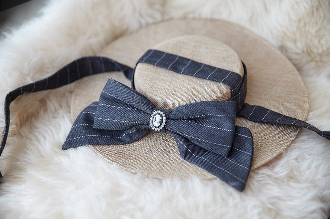 Vintage lolita flat hat with refined metal embellishments and cameo centerpiece, detailed close-up of the bow structure and decorative elements