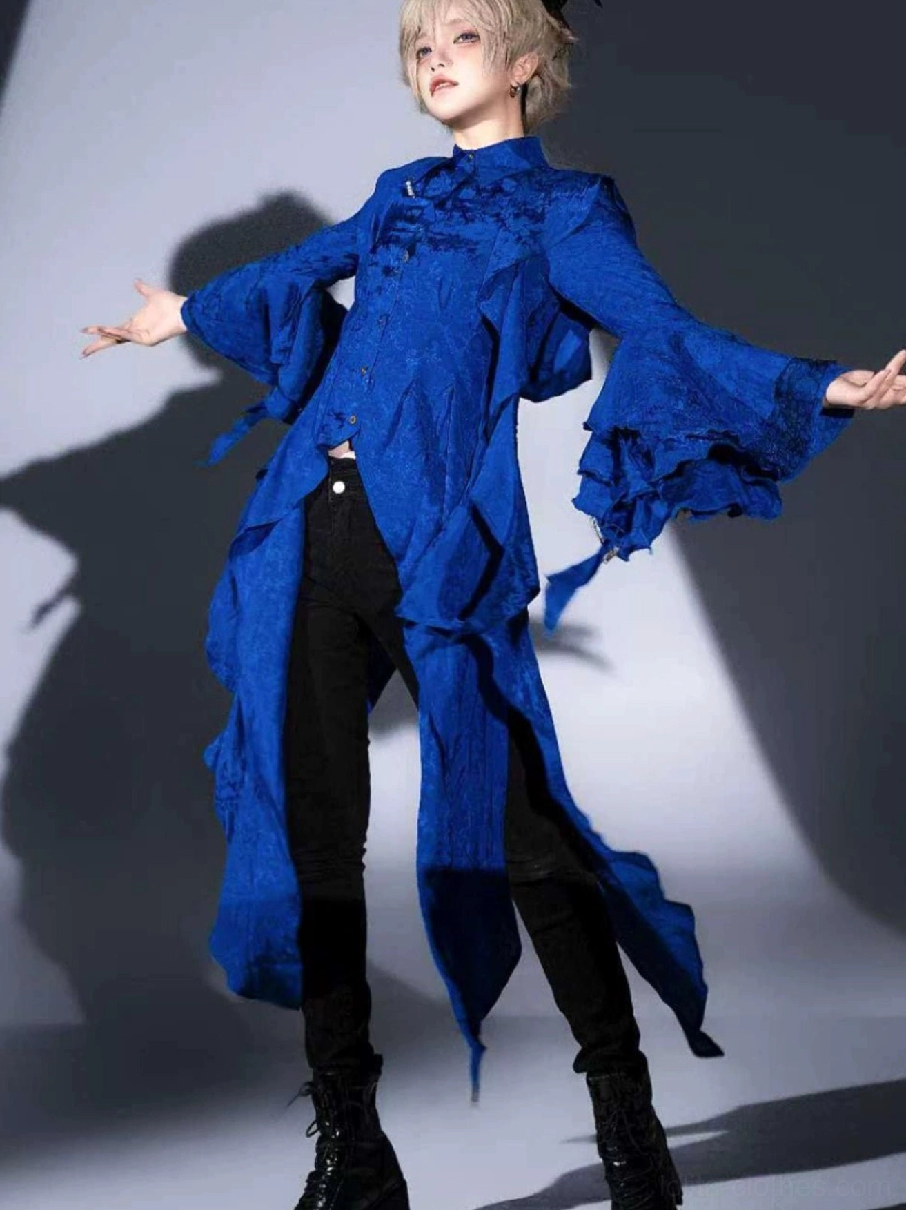 Front full-body portrait of model in royal blue Ouji Lolita asymmetrical shirt featuring flared ruffled sleeves, dramatic irregular hemline, jacquard stand collar, perfect for formal gothic coordinates