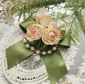 Sage green lolita flower bow choker necklace with champagne pink artificial roses pearl chain decoration and large satin ribbon bow on embroidered lace backdrop