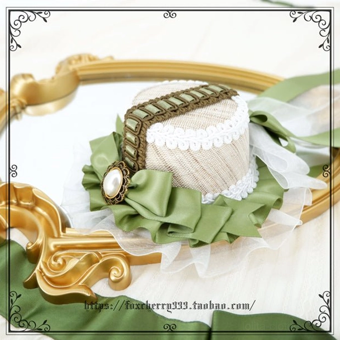 Sage green Lolita mini top hat headdress displaying side profile view with decorative striped band ruffled base and sheer organza trims