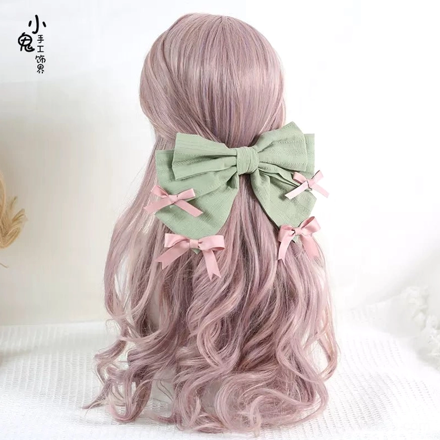 Sage green bowknot back hair clip for lolita fashion back view on pink curly wig mannequin with pink small bow accents sweet lolita hairstyle