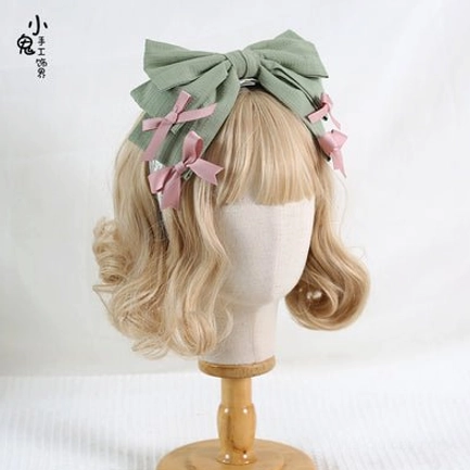 Sage green bowknot lolita hair headband with matching pink small bow trims on blonde mannequin head lolita fashion styling