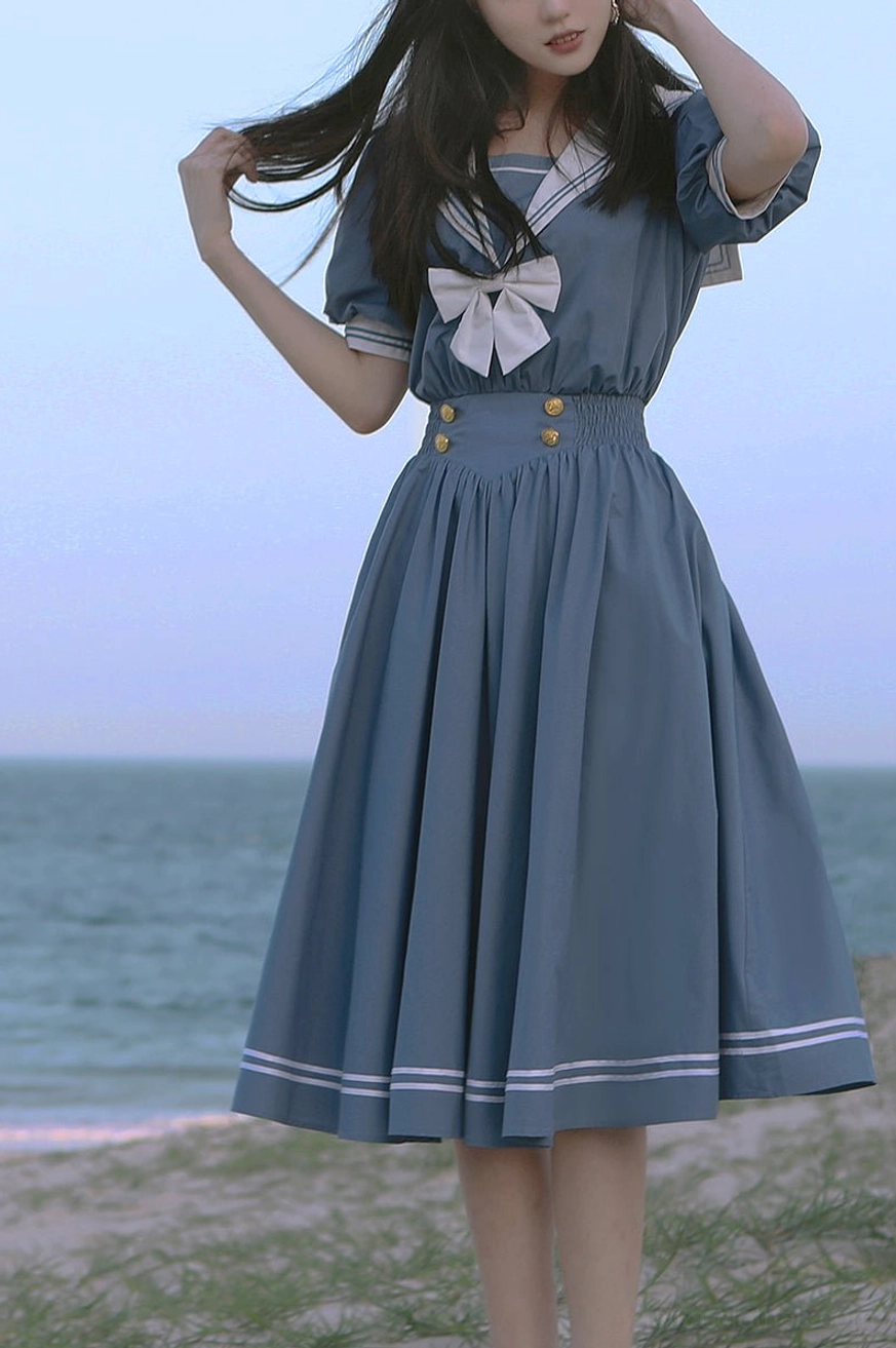 Sailor lolita OP dress back view showing waist sash bow construction shirred high waist line A-line skirt silhouette nautical aesthetic rear perspective