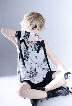 Shadow Story Ouji lolita sleeveless gothic shirt with black and white strawberry wing print, detachable cuffs and ribbon accessories, modeled by blonde male in sitting pose with grey studio backdrop