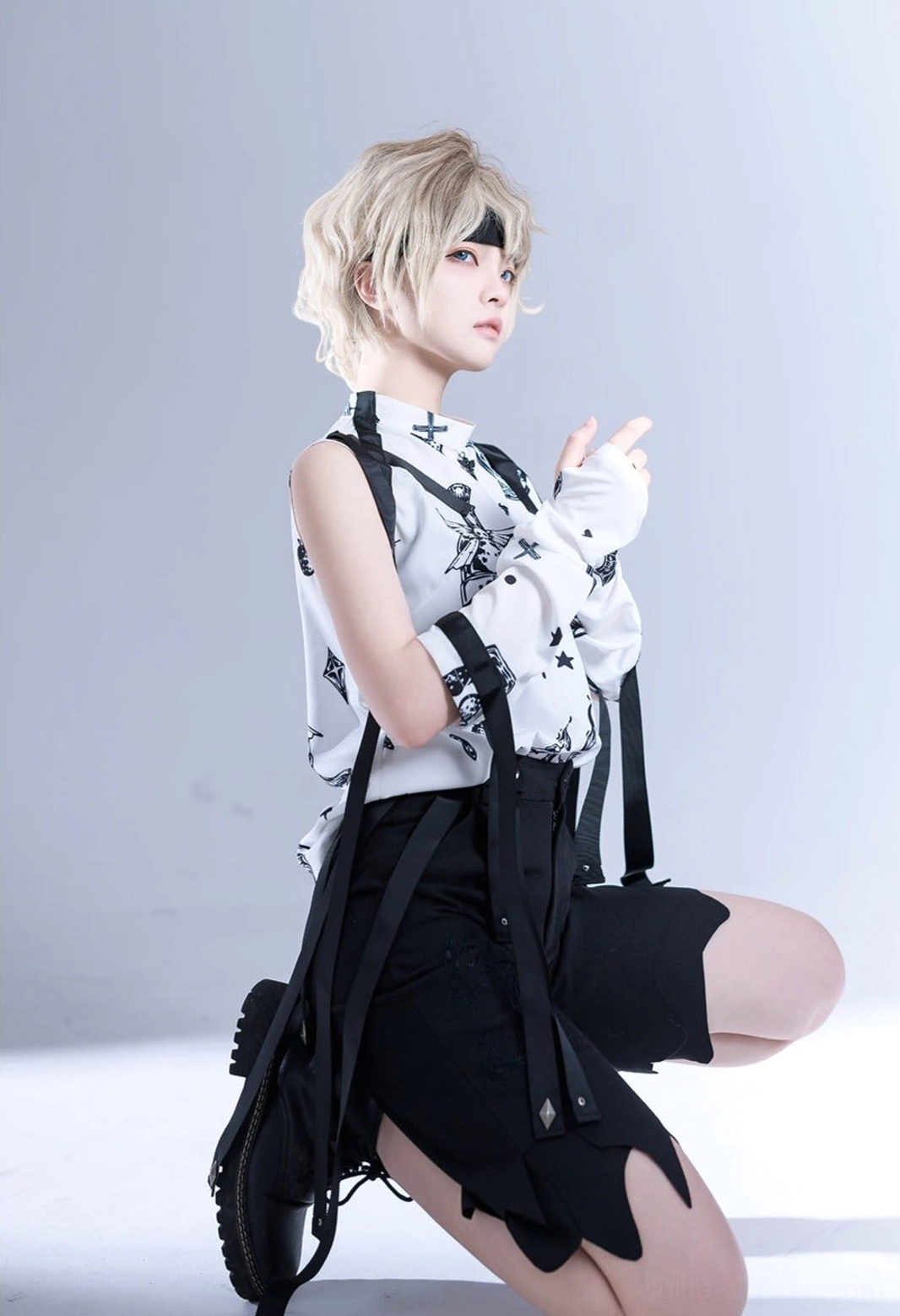 Low-angle kneeling frontal pose of Shadow Story black and white lolita sleeveless shirt, highlighting shoulder straps, ribbon accessories, and overall construction details
