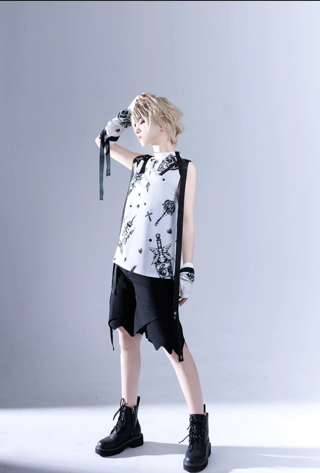 Side standing pose displaying Shadow Story Ouji lolita black and white sleeveless shirt, showing the length and fit of the gothic garment with decorative shoulder elements
