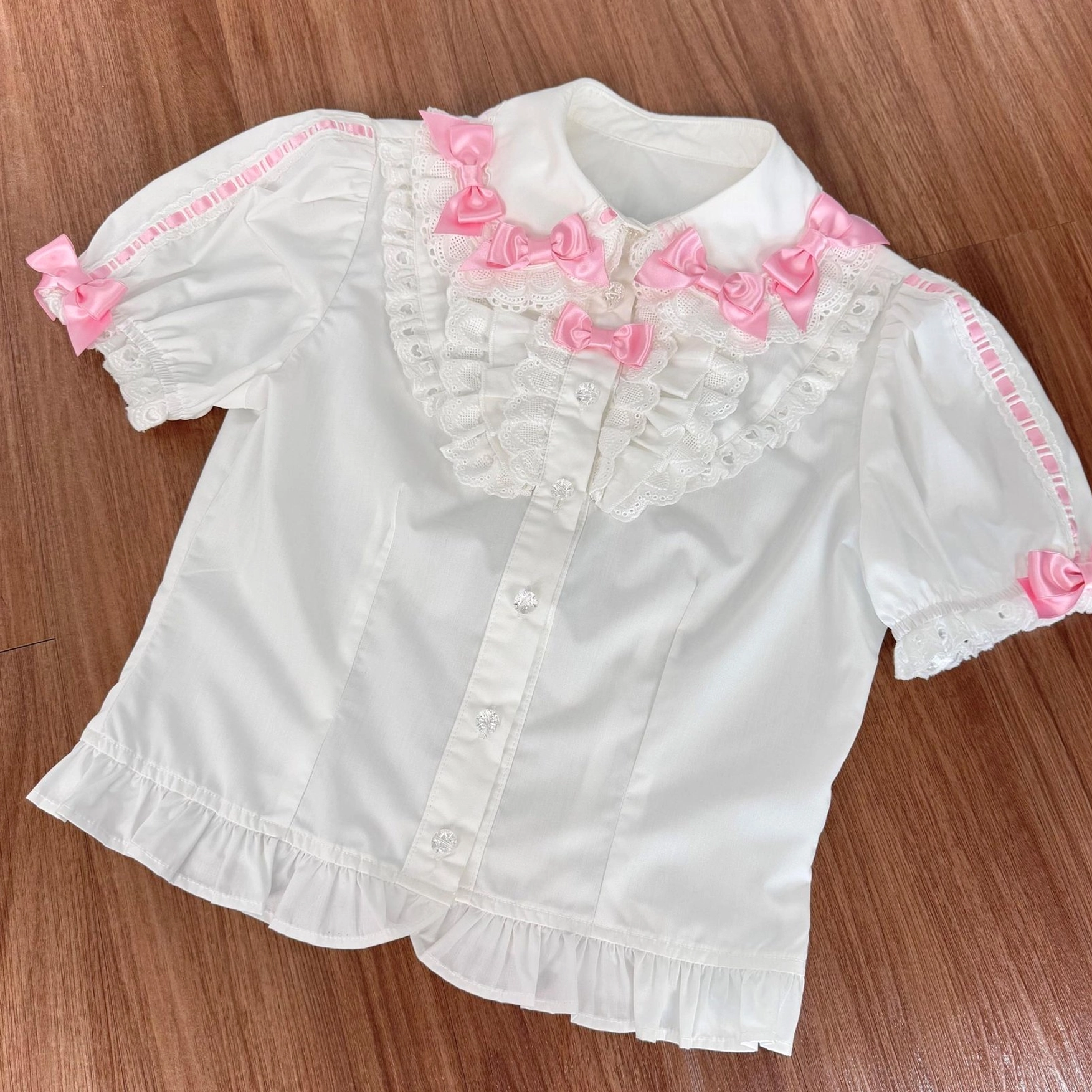 Short sleeve blouse for old school lolita coordinate in white with pink ribbon bows, showing classic sweet lolita blouse construction and structured fit suitable for pairing with jsk dress