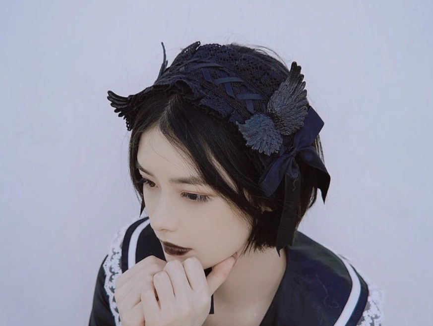 Side profile close-up model with braided black lace headband wing and side bow details wearing sailor lolita dress studio background