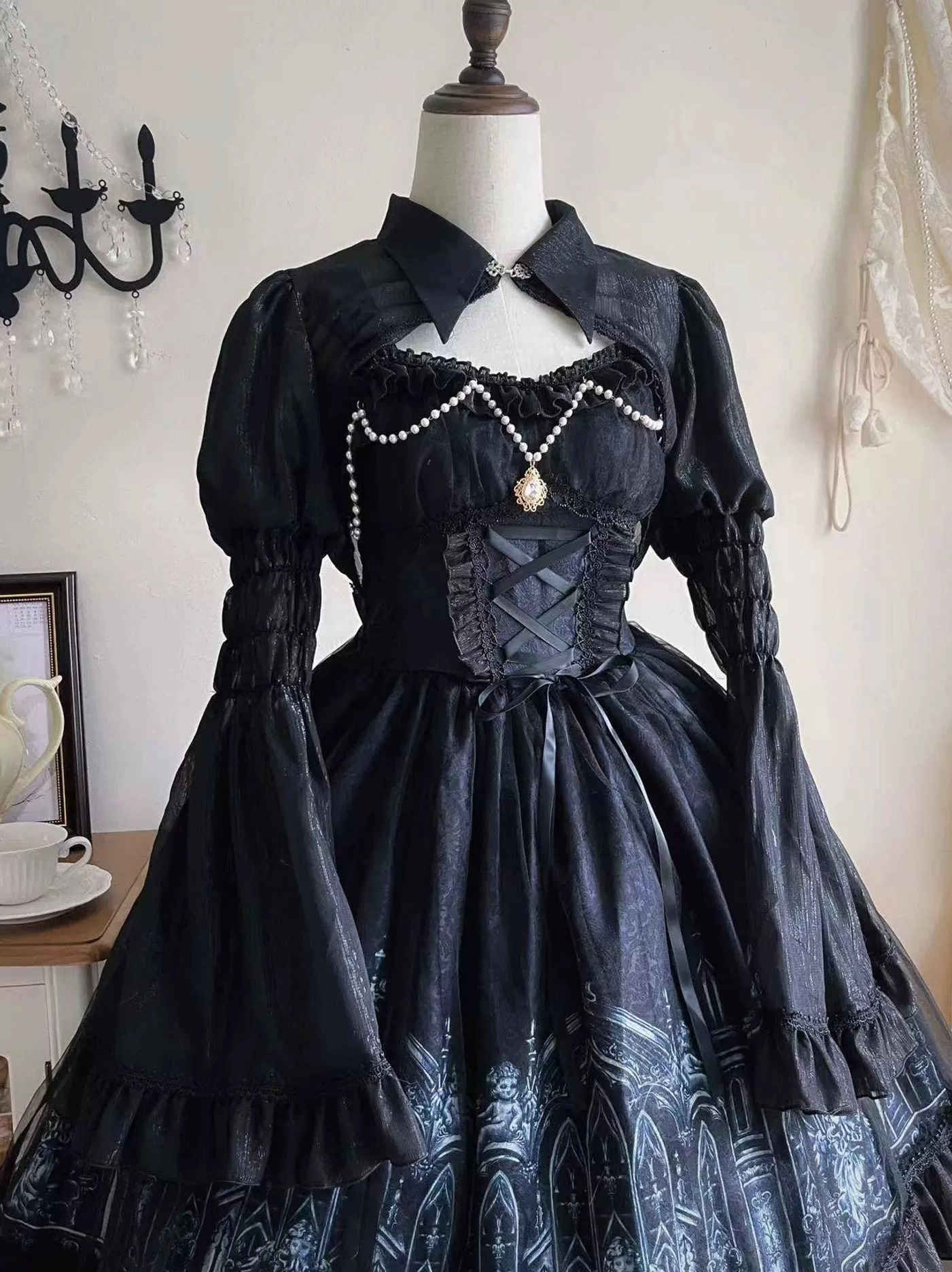 Dress form display of Silent Night gothic lolita JSK dress three-quarter frontal angle showing cutout high collar, pearl chest ornament with gold accent, corset-style bodice stitching, and full silhouette