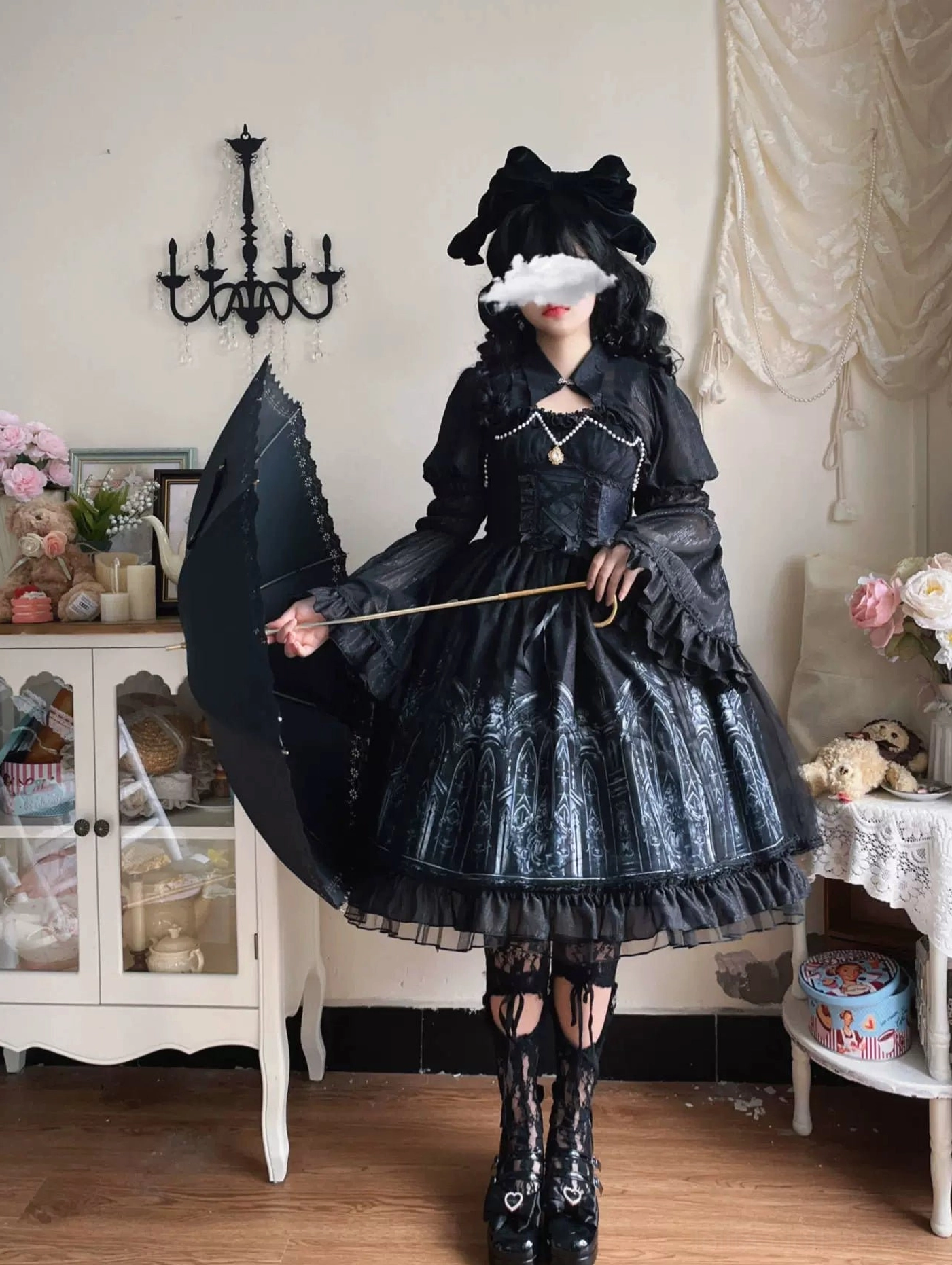 Model posing with open black gothic parasol wearing Silent Night lolita dress, full body front view showcasing pearl chest pendant, gold handle accent, and complete vintage dark aesthetic