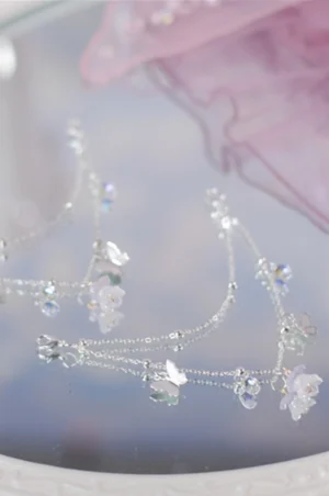 Close view of silver floral butterfly bridal shoe chain with faceted crystal beads and translucent resin charms