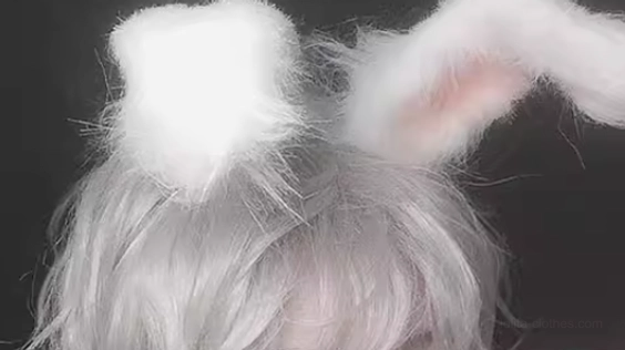 Mannequin head display of silvery gray slightly short curly wig with attached fluffy rabbit ear decorations