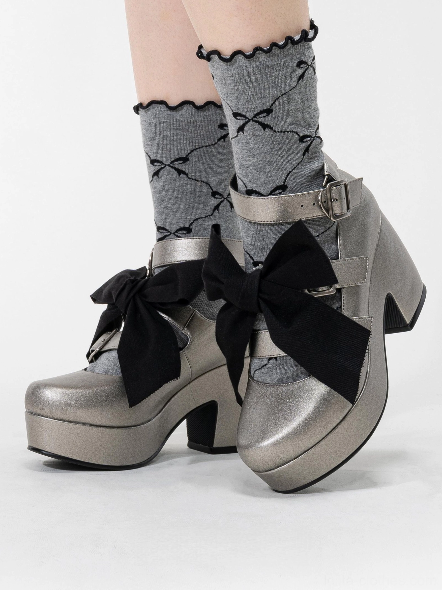 Silver-grey Gothic Lolita platform heel shoes with detachable bow and patterned ruffled crew socks, chunky platform heel, adjustable silver buckle ankle straps, front oblique view on model legs