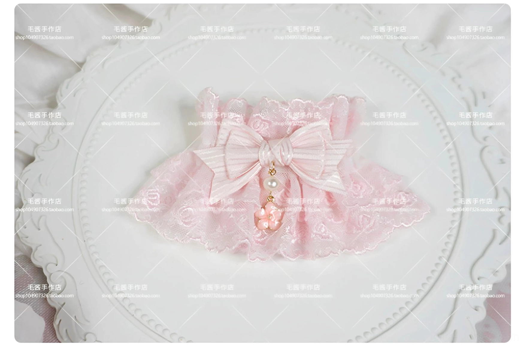 single pink sweet lolita lace wrist cuff flat lay on vintage white tray showing rose patterned lace, striped satin bow, and pearl flower bead drop pendant with ruffled edge