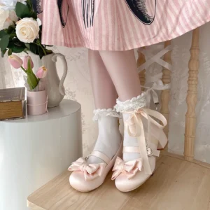 Blush pink Sweet Lolita satin Mary Jane low chunky heel shoes with dual front bow, displayed with white frilled ankle socks and striped pink lolita dress coordinate