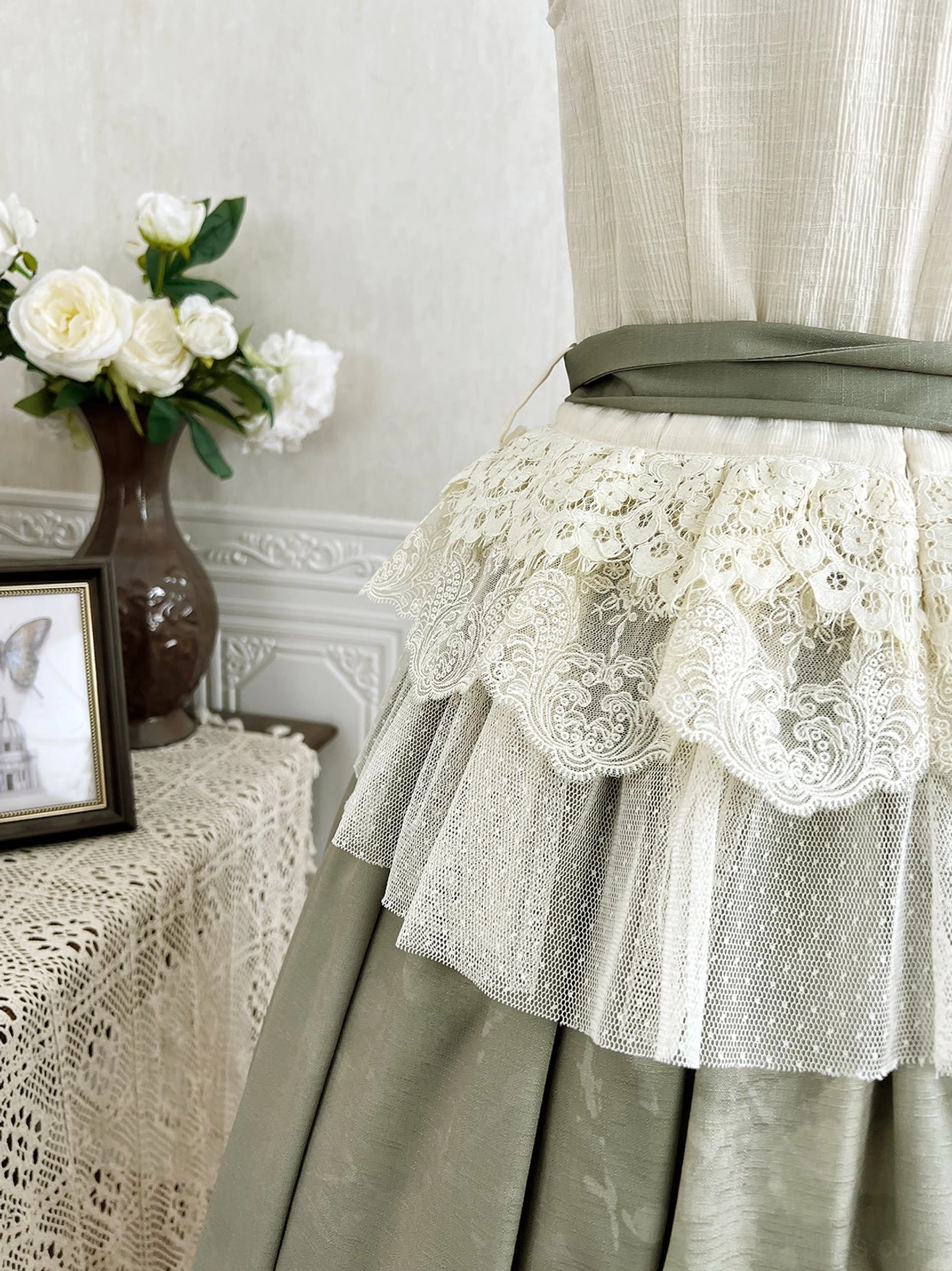 Back close-up detail of skirt showing scalloped cream lace waist overlay and matching sage green fabric waistband complementing vintage lolita aesthetic
