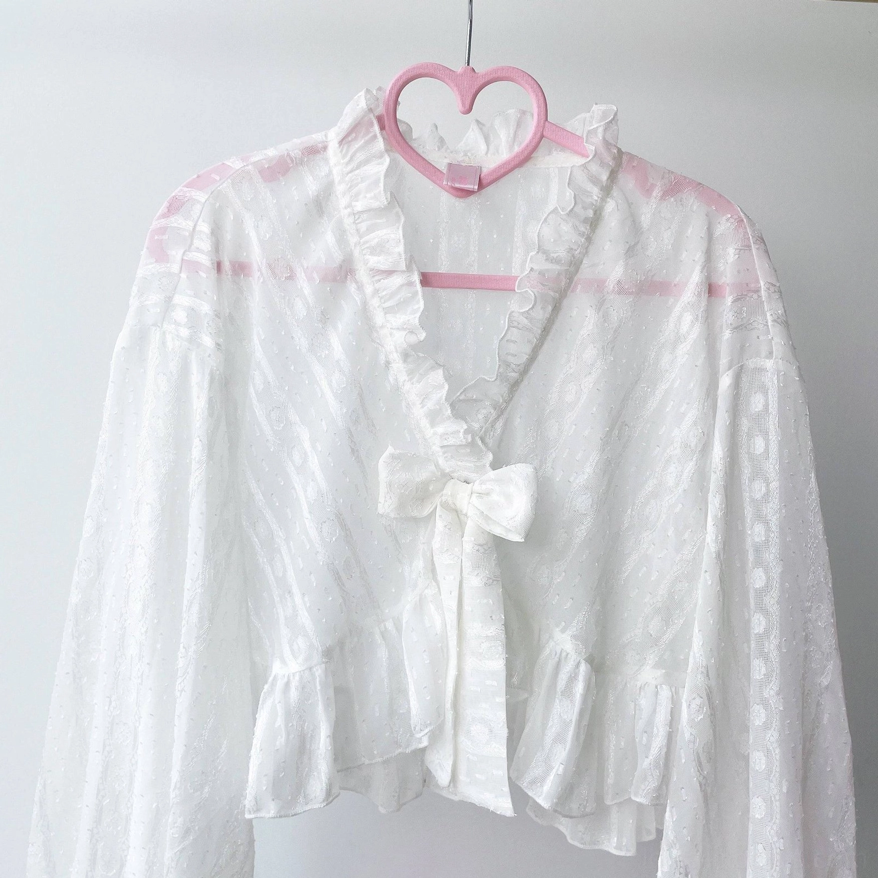 Light sky blue sheer chiffon puff sleeve Lolita cropped cardigan with ruffled cuffs worn on model with blue gingham cake dress