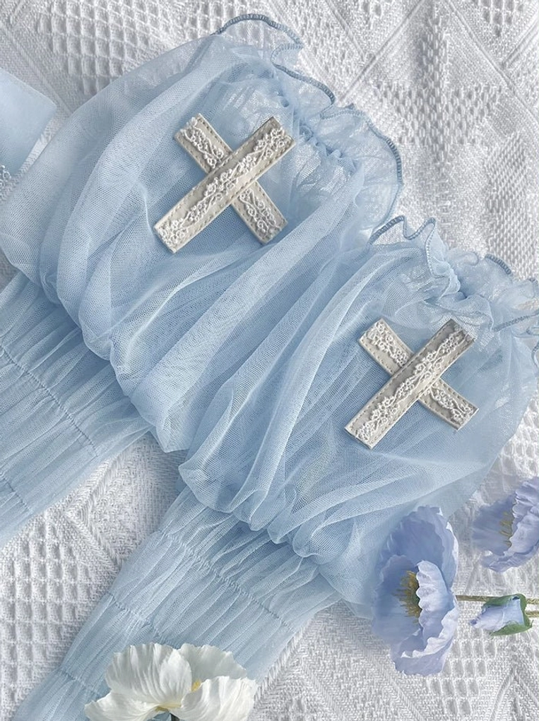 Sky blue Gothic Lolita arm cuffs with embroidered cross appliques and ruffled frilled edges, decorated with purple and white flowers on linen backdrop