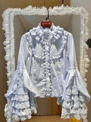 Sky blue cotton Lolita blouse with ruffled collar and multi-layer lace flared sleeves, elegant hanging display