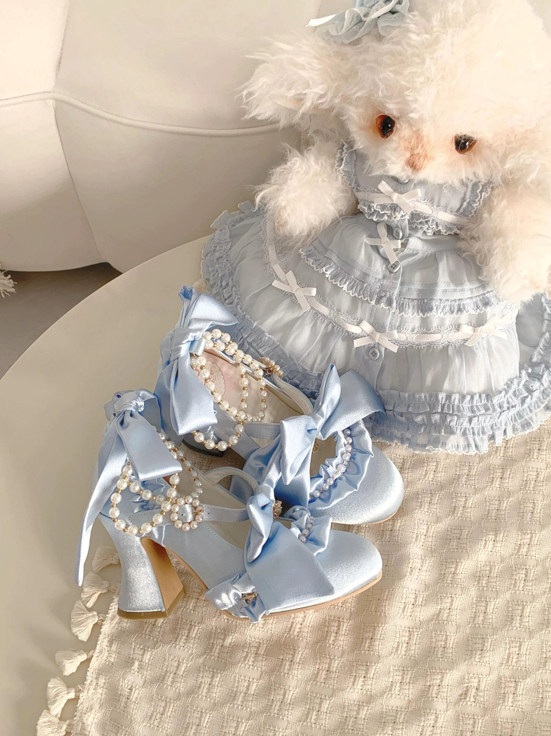 Light blue sky-blue satin bow wedding lolita high heels with pearl chain embellishments and chunky block heel on round table