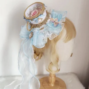 sky-blue organza rococo teacup lolita hat with preserved pink rose pearl brooch gold lace trim front three-quarter view on mannequin