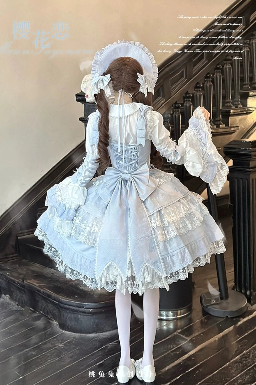 Back view of sky blue Sakura Love lolita dress suit featuring large decorative back bow, multi-tier satin and lace skirt, long puff sleeves, braided twin hairstyle with hair ornaments